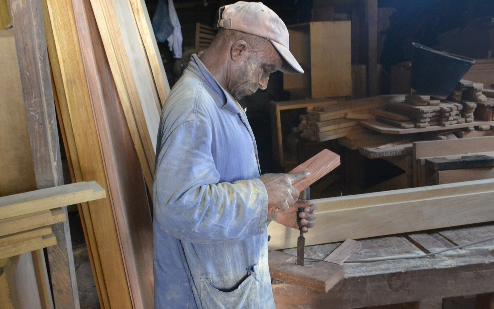 Carpenter shaping wood with a chisel in a workshop